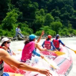 Adventurers experienced in Dandeli River Rafting navigating thrilling rapids amidst lush forest